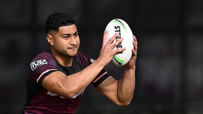 A Brisbane broncos player holding a football at training