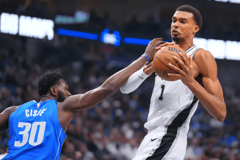 against the Dallas Mavericks caption San Antonio Spurs forward Victor Wembanyama led the scoring with 23 points, helping his team secure a 122–106 victory over the Dallas Mavericks for their first win of the NBA season.